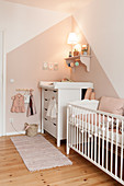 Cot and changing unit in pink and white nursery