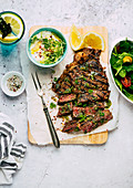 Grilled beef steak with tzatziki and salad