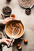 Hands mixing a bowl of brownie batter
