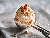 A scoop of walnut ice cream in an ice cream scoop