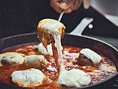 Meatballs baked in tomato sauce with cheese