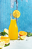 Bottle of fresh orange juice with sliced citrus fruits