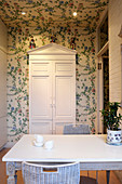 Floral Chinoiserie wallpaper in kitchen with white painted furniture