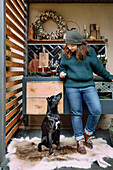 Woman and dog in front of outdoor kitchen decorated for Christmas