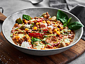 Colorful pizza soup with bell pepper, corn and basil