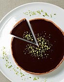 Chocolate and pistachio pie on white plate