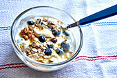 Muesli with oat flakes, walnuts, yogurt, blueberries and honey
