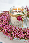 Candle lantern in wreath of heather decorated with rose and gypsophila