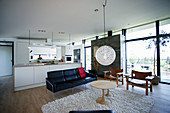 Küche und Sitzbereich in offenem Wohnraum mit Glasfront