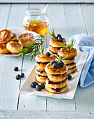 Mini-Pancakes, gestapelt mit Rosmarin, Blaubeeren und Sirup