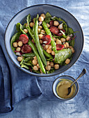 Salad prepared from spinach, sausage, chickpea and green beans