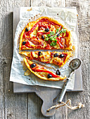 Pizza mit marinierter Paprika und schwarzen Oliven