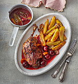 Roasted duck with cherries and baked potatoes