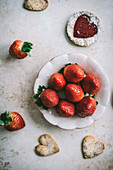 Ein Schälchen mit Erdbeeren daneben Kekse