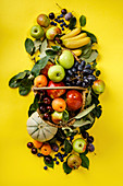 Fresh fruits and berries on yellow background