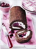 Chocolate Cherry Roulade with knife and cherries in a bowl