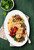 Turkey breast with baked tomatoes and spinach on tagliatelle
