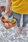 Frau hält einen Picknickkorb mit Obst und Nougatbrot