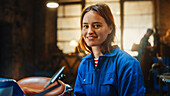 Smiling mechanic in workshop clothing