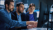 Team of industrial engineers working on computer