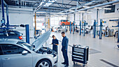 Mechanics inspecting a car