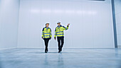 Engineers walking through an empty warehouse