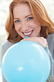 Woman blowing up balloon