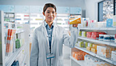 Pharmacist holding a box of vitamins