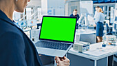 Engineer holding a green screen laptop