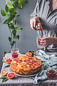 Blood orange upside down cake and woman pouring juice