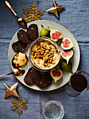 Vacherin-Käsefondue mit Haselnüssen serviert dazu Feigen und Früchtebrot (Weihnachten)
