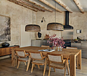 Solid wood dining table, pendant lights above, kitchen unit in the background