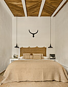 Double bed with natural woven headboard in the bedroom with a reed ceiling