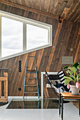 Room with rustic wood panelling and glass panel in floor