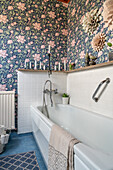 Bathtub in bathroom with floral wallpaper