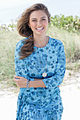 A young woman with long hair wearing a blue patterned dress