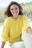 A young woman with long hair wearing a yellow jumper and trousers