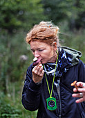 Woman smelling wild mushroom