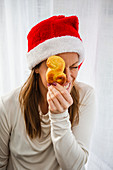 Frau mit Weihnachtsmütze hält Safranbrötchen