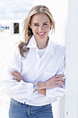 A long-haired blonde woman wearing a white shirt blouse