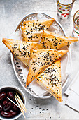 Filo pastry corners with black sesame and olives