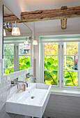 Sink in a bathroom with window and wooden beams