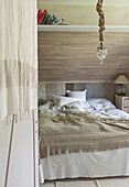 Doppelbett im Schlafzimmer in Beige- und Grautönen