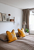Yellow throw pillows with horse motif on a queen size bed