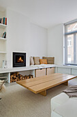 Custom coffee table, fireplace and L-shaped bench in white living room
