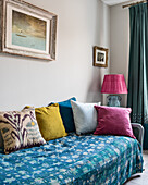 Tagesbett mit blauer Decke und bunten Kissen