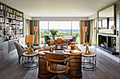 Leopard print chair at antique desk with accents of orange and view of Sussex countryside