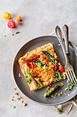 Tart on puff pastry with asparagus, cherry tomatoes, and Parmesan crumble
