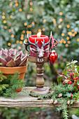 A deer candlestick with a red candle placed outdoors