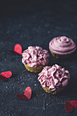 Cupcakes mit rosa Frosting zum Valentinstag auf dunklem Untergrund